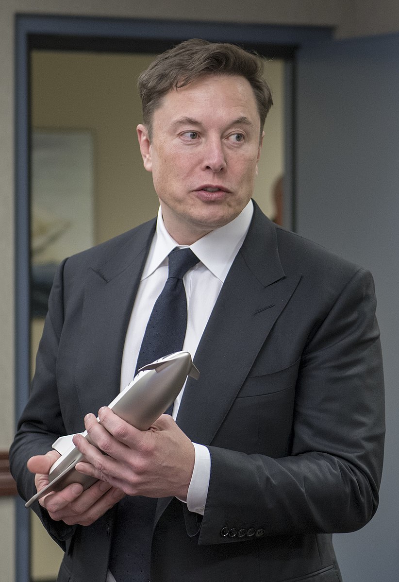 photo portrait of Elon Musk holding spaceship prototype model