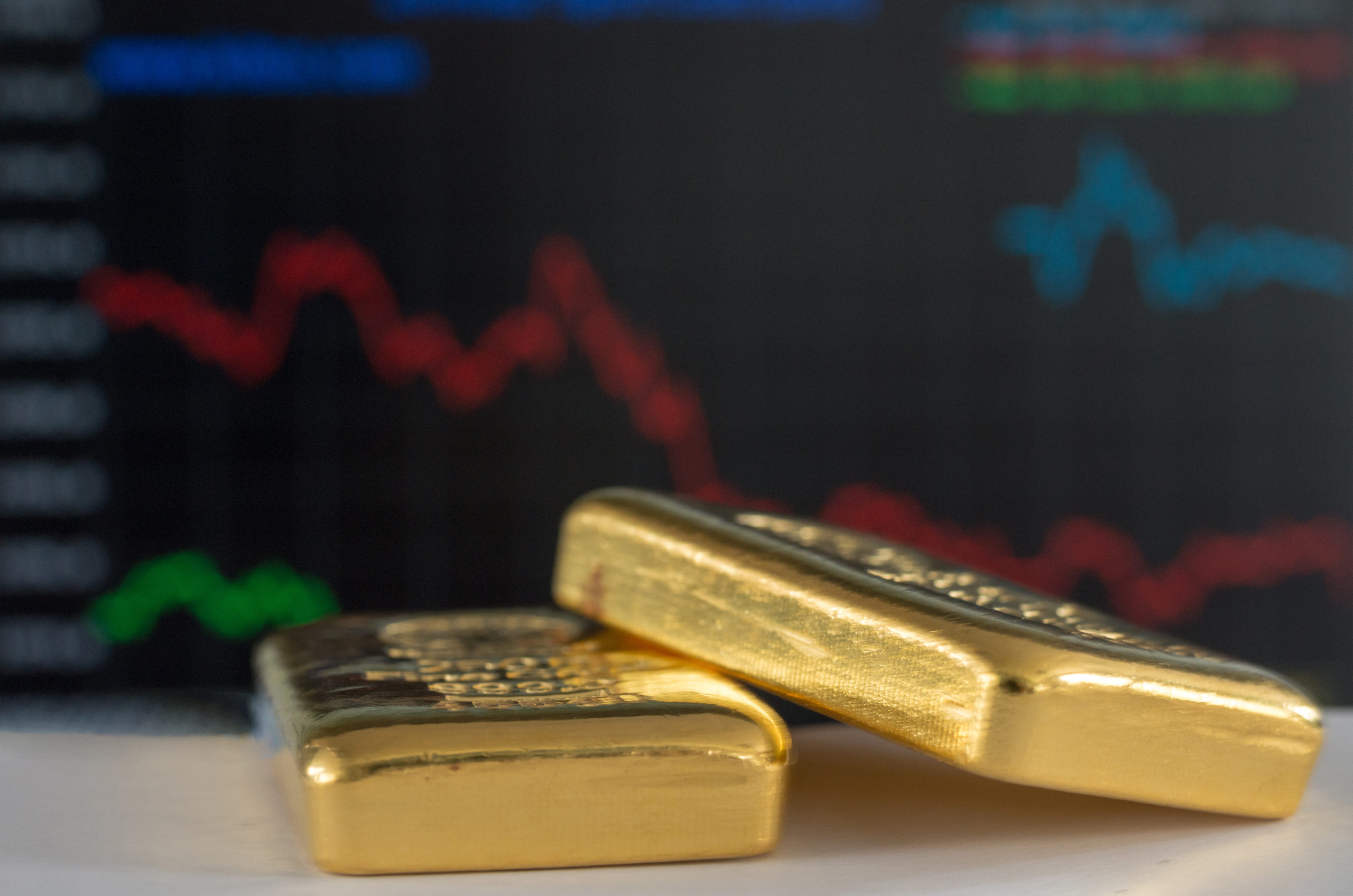 photo image of gold bars with colorful chart in background