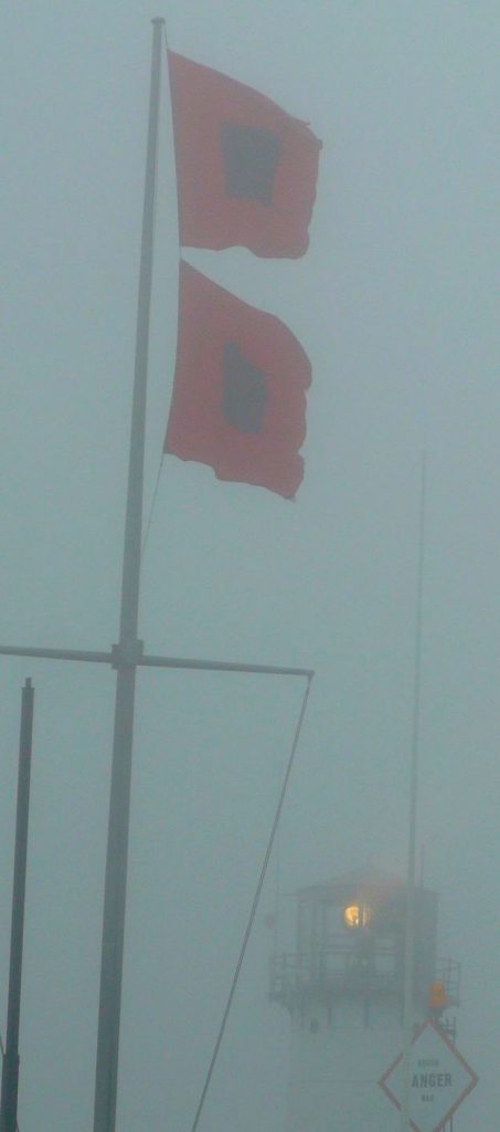photograph of red hurrican warning flags stiff wind